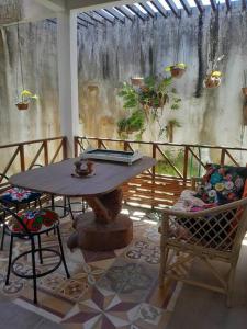 a patio with a table and a chair and a bench at Casa Charmosa Verde-Azul in Paracuru