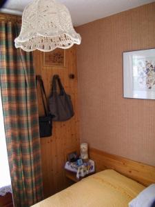 1 dormitorio con 1 cama y una lámpara de araña colgada de la pared en Residence Les Choseaux - 2 Pièces pour 6 Personnes 764, en Valloire