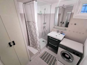 uma pequena casa de banho com um chuveiro e um lavatório. em Résidence Maisons Des Sables - Pièces 564 em Leucate