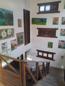 a dining room with a table and paintings on the wall at Casa Charmosa Verde-Azul in Paracuru