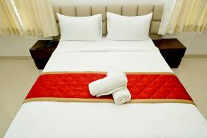 a hotel room with a bed with a towel on it at The Mallika Sapphire in Chikmagalūr