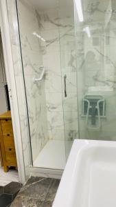 uma casa de banho com um chuveiro, uma banheira e um lavatório. em Charmant logement parking gratuit, gare proximité em Sevran