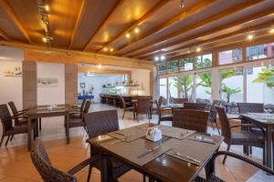 a dining room with tables and chairs and windows at whala!tenerife in Playa de las Americas