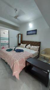 um quarto com uma cama grande e uma cadeira em UNiTY MADHAV HOMESTAY em Kevadia