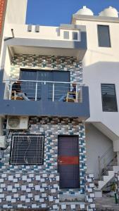 um edifício com uma varanda com cadeiras em UNiTY MADHAV HOMESTAY em Kevadia