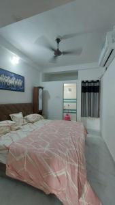 um quarto com uma cama grande e uma ventoinha de tecto em UNiTY MADHAV HOMESTAY em Kevadia