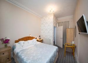 1 dormitorio con 1 cama y TV en una habitación en Monaco Hotel, en Weston-super-Mare