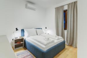 - une chambre avec un lit bleu et blanc et une fenêtre dans l'établissement Mare Sano apartment #1, à Opatija
