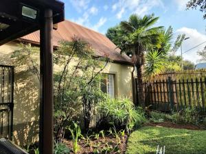 a house with a fence and a palm tree at The Grace in Pretoria