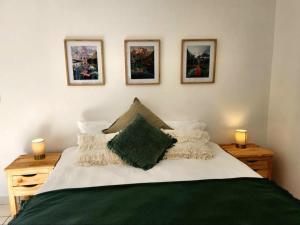 ein Schlafzimmer mit einem großen Bett mit drei Bildern an der Wand in der Unterkunft The Grace in Pretoria