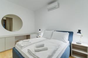 - une chambre avec un lit et un miroir mural dans l'établissement Mare Sano apartment #1, à Opatija