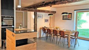 a kitchen and dining room with a wooden table and chairs at Résidence Maison - Maisons & Villas pour 8 Personnes 094 in Vallouise