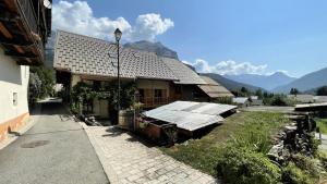 a house with a roof with mountains in the background at Résidence Maison - SUPERBE MAISON DE VILLAGE FAMILIALE 8 PERS MAE-9094 in Vallouise