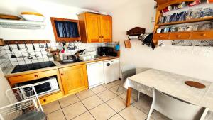 a kitchen with wooden cabinets and a table with chairs at Résidence Queyrettes - 2 Pièces pour 4 Personnes 134 in Puy-Saint-Vincent