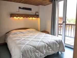 a bedroom with a white bed and a balcony at Chalet L'armoise - Chalets pour 14 Personnes 954 in Tignes