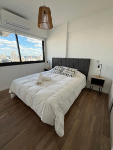 1 cama blanca grande en un dormitorio con ventana grande en Boreas Tango en Buenos Aires