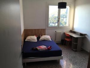 1 dormitorio con cama, escritorio y ventana en Résidence La Rouviere - 5 Pièces pour 8 Personnes 724 en Marsella