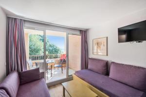 a living room with a purple couch and a balcony at Résidence La Pinède - maeva Home - Studio 4 Personnes - Sélection 19 in Hyères