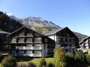 un edificio con una montaña en el fondo en Résidence Combettes - 3 Pièces pour 5 Personnes 324 en Les Contamines-Montjoie