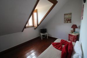 a bedroom with a bed with red sheets and a window at Casas da Biquinha in Sintra