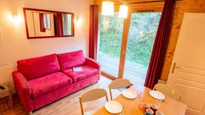 een woonkamer met een rode bank en een tafel bij Chalet De Florence - Studio pour 4 Personnes 894 in Modane