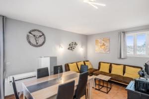 uma sala de estar com uma mesa e um sofá em Village Pont Royal en Provence - maeva Home - Appartement duplexe moderne 4 Piè em Mallemort
