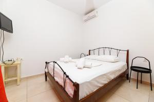 a bedroom with a bed with white sheets and a tv at Bougainvillea in Georgioupolis +41 photos