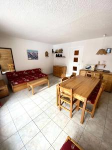 uma sala de estar com uma mesa de madeira e um sofá em Résidence Prapelier - Studio pour 4 Personnes 774 em Vénosc