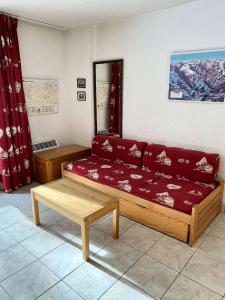 uma sala de estar com um sofá e uma mesa em Résidence Prapelier - Studio pour 4 Personnes 774 em Vénosc