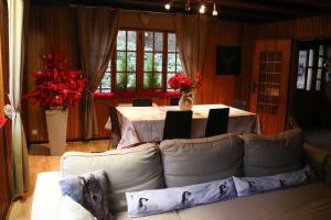a living room with a couch and a table with flowers at Chalet au bord de l’eau in Saint-Quirin
