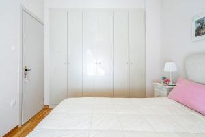 a white bedroom with a large bed and white cabinets at Lovely 1 Bd apt in Kalithea with Balcony in Athens