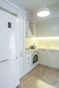 a kitchen with white cabinets and a stove top oven at Lovely 1 Bd apt in Kalithea with Balcony in Athens