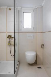 a bathroom with a shower and a toilet and a window at Lovely 1 Bd apt in Kalithea with Balcony in Athens