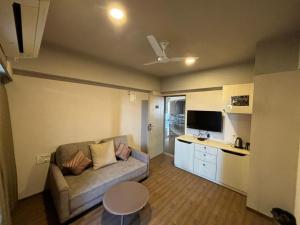 a small living room with a couch and a table at Weekend Address By Honest Homes in Surat