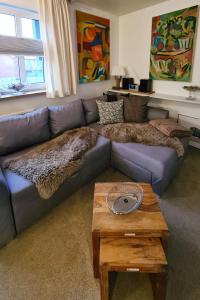ein Wohnzimmer mit einem blauen Sofa und einem Tisch in der Unterkunft Inselresidenz Strandburg - Ferienwohnung 210 (Ref. 50967u2) in Juist