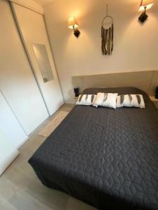 ein Schlafzimmer mit einem großen schwarzen Bett mit zwei Kissen in der Unterkunft Résidence Debussy - maeva Home - Appartement 2 Pièces 4 Personnes - Select 39 in Carnoux