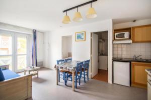 a kitchen and dining room with a table and chairs at Residence Debussy - maeva Home - Appartement 2 Pièces 4 Personnes - Budget MAE-9049 in Carnoux
