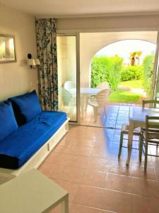 een woonkamer met een blauwe bank en een tafel bij Résidence Rivages - 2 Pièces pour 5 Personnes 654 in Six-Fours-les-Plages