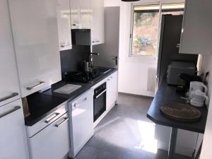 a kitchen with white appliances and a black counter top at Résidence Rouviere - 5 Pièces pour 8 Personnes 684 in Marseille