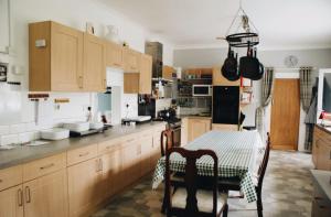 cocina con armarios de madera y mesa con mantel en Ranscombe House en Brixham