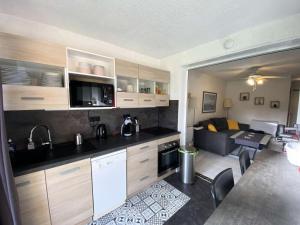 uma cozinha e sala de estar com um sofá num quarto em Résidence Pinedes Aryana - 4 Pièces pour 6 Personnes 754 em Six-Fours-les-Plages