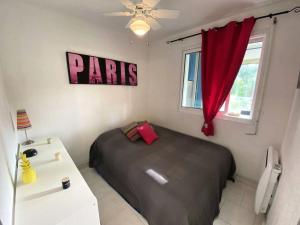 1 dormitorio con cama y cortina roja en Résidence Pinedes Aryana - 4 Pièces pour 6 Personnes 754, en Six-Fours-les-Plages