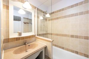 ein Badezimmer mit Waschbecken, Spiegel und Badewanne in der Unterkunft Les maisons Le Rouret - maeva Home - Maison 3 Pièces 6 Personnes - Sélection MAE-9200 in Grospierres + 28 Fotos