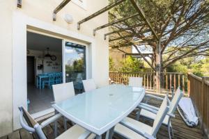 eine Terrasse mit einem Glastisch und Stühlen auf einer Terrasse in der Unterkunft Les maisons Le Rouret - maeva Home - Maison 3 Pièces 6 Personnes - Sélection MAE-9200 in Grospierres