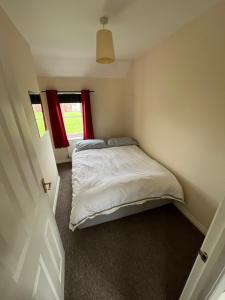 Habitación pequeña con cama y ventana en 2 bed coach house flat Hereford, en Hereford