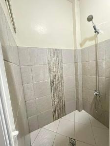 y baño con ducha y cortina de ducha. en JBR Cozy Bed & Breakfast, en Cebú