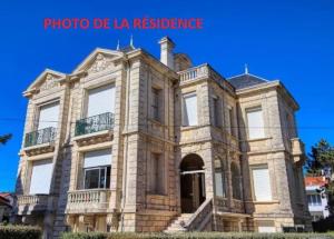 ein großes Steinhaus mit blauem Himmel im Hintergrund in der Unterkunft Appartement Cosy à 20 mètres de la plage in Royan