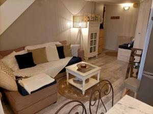 ein Wohnzimmer mit einem Sofa und einem Tisch in der Unterkunft Appartement Cosy à 20 mètres de la plage in Royan