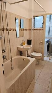 ein Badezimmer mit einer Badewanne, einem Waschbecken und einem WC in der Unterkunft גדולה ומעוצבת ברעננה in Ra‘ananna