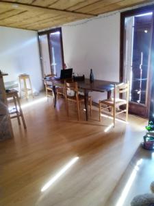 a dining room with a wooden table and chairs at Savoie, Simple mais confortable in Villard-sur-Doron